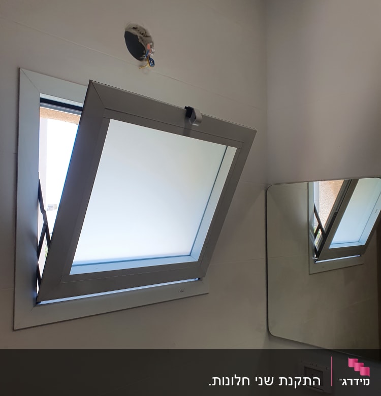 חלון אלומיניום פתוח עם מסגרת כסופה